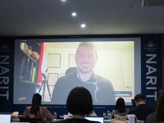 A photo of Dr. Alfredo Carpineti presenting the workshop on a screen with several attendees watching