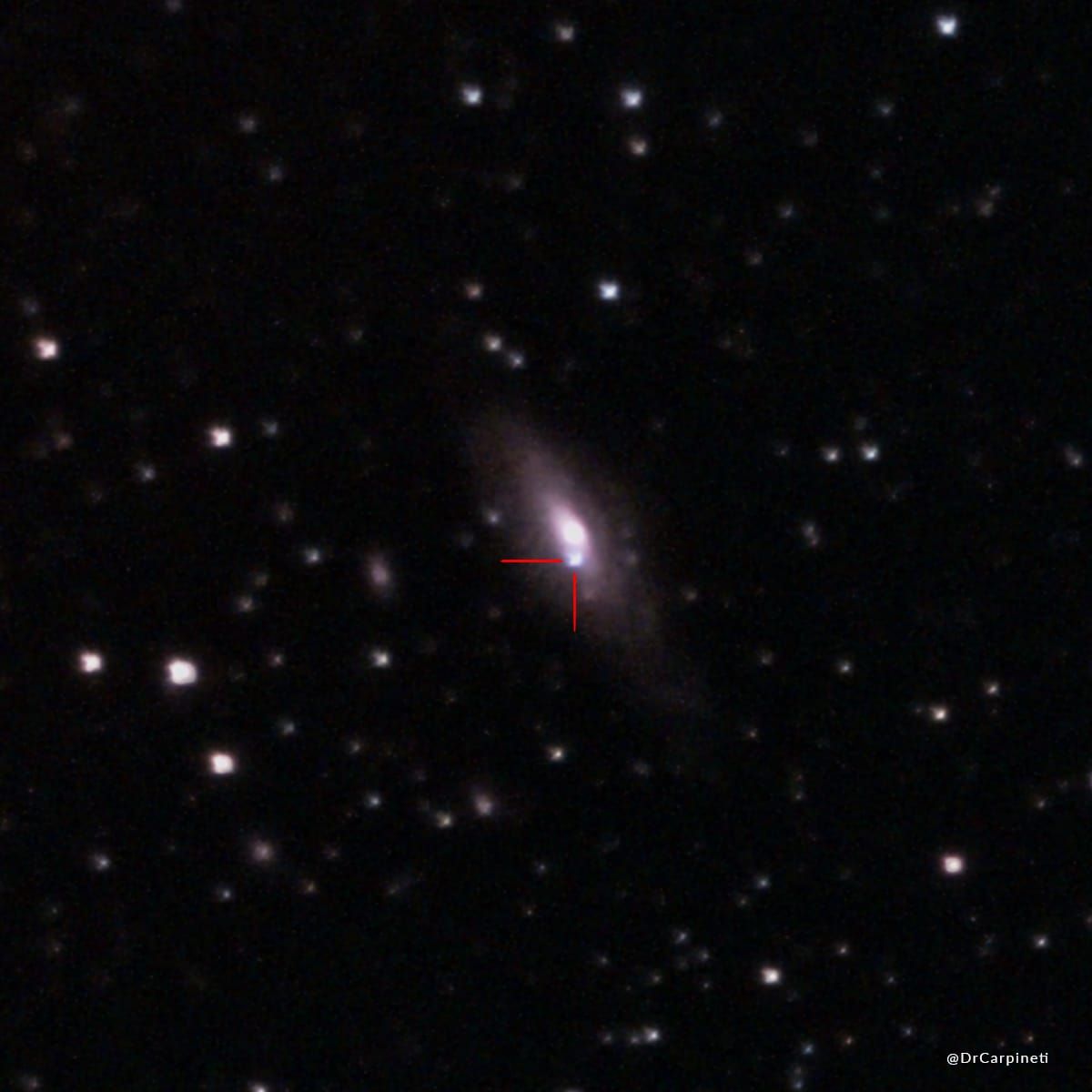A spiral galaxy is in view in the middle of the image and a bright dot is seen right south of center