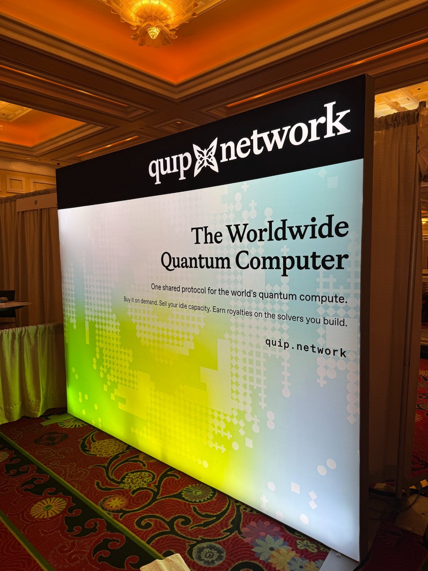 The Quip Network booth backdrop reading The Worldwide Quantum Computer.