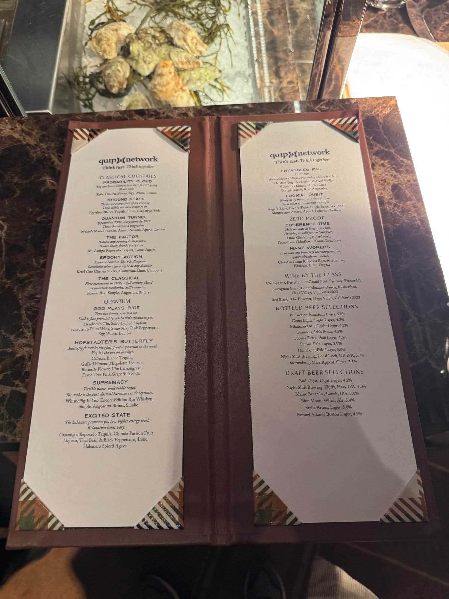 The custom Rare Qubits cocktail menu with quantum-themed drink names.
