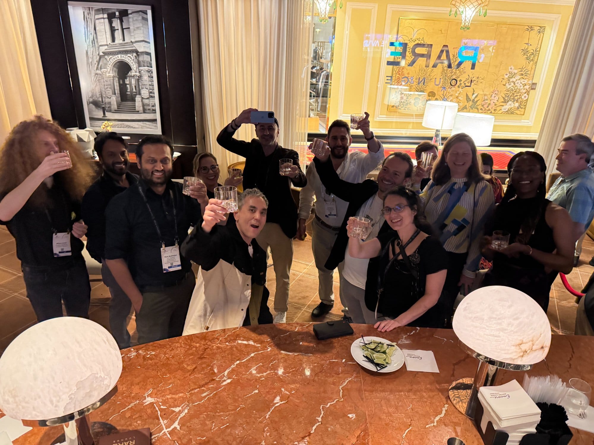 Attendees raising glasses in a toast at the Rare Qubits reception in the Rare Lounge at Encore Boston Harbor.