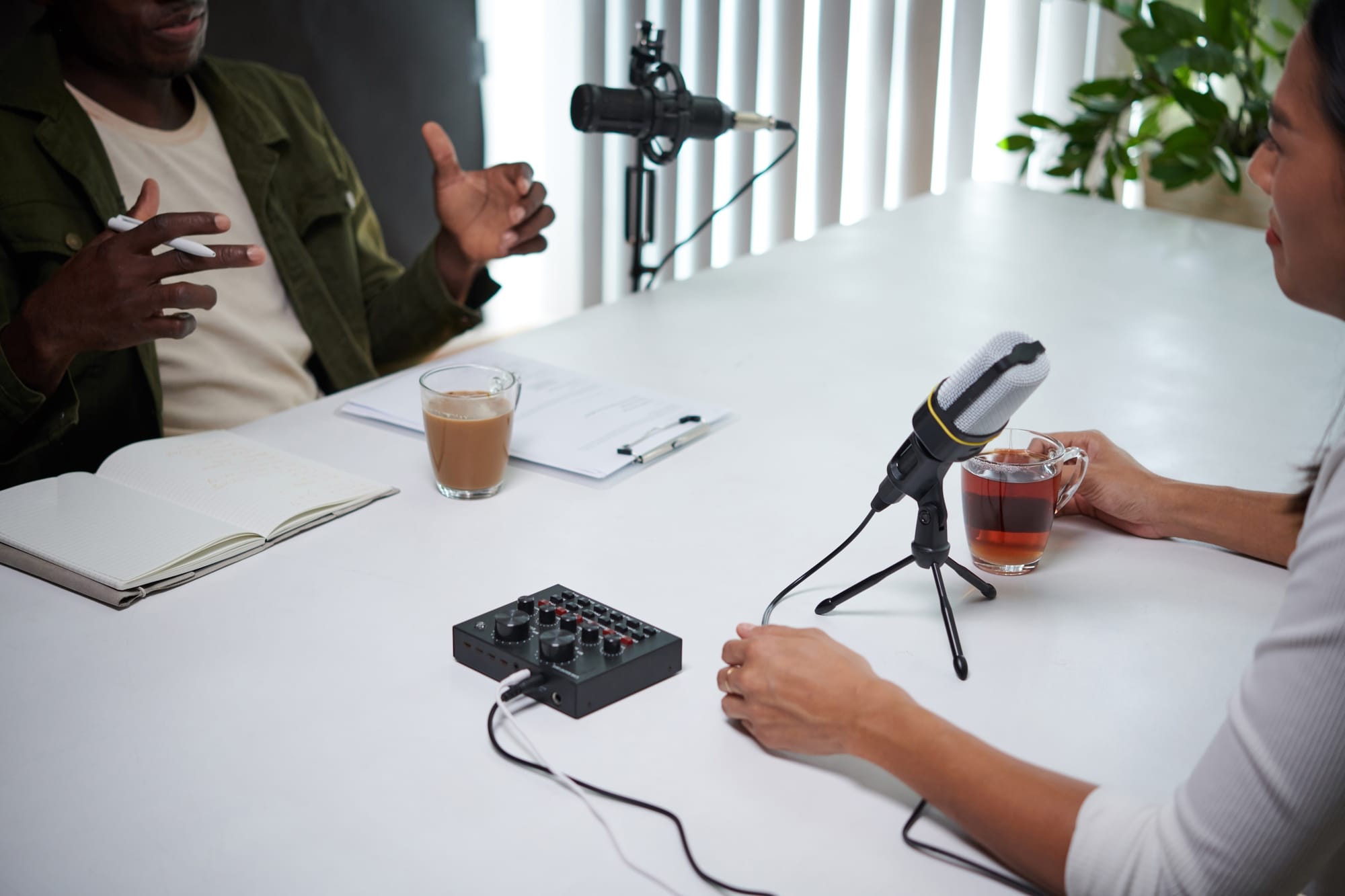 Podcast host and guest recording interview with discussion notes