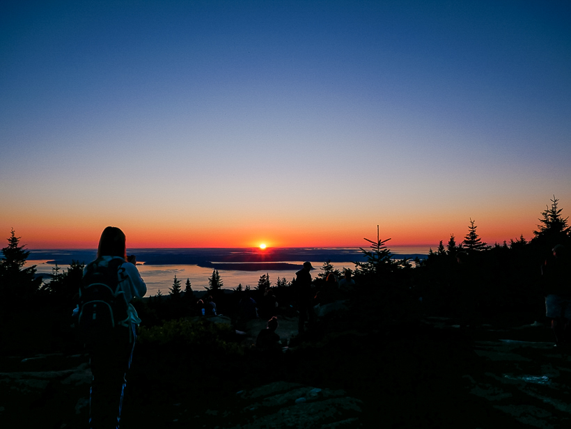Sunrise peaking over the horizon from the summit of Cadillac Mountain in Maine