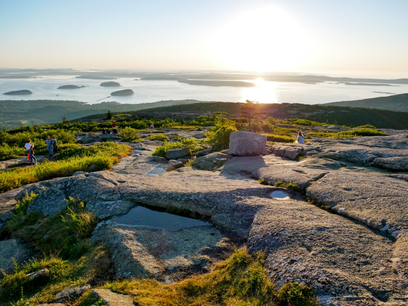 Find a place to sit on the slopped granite rocks overlooking Frenchman Bay
